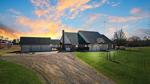 a view of a house with a big yard and a large tree