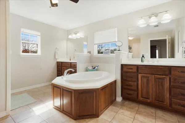 a spacious bathroom with a tub sink and mirror