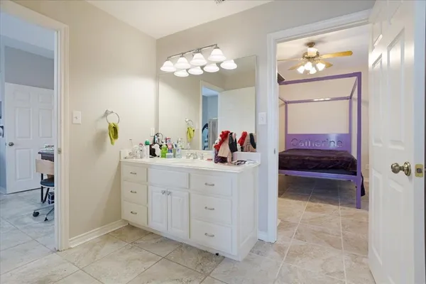 a spacious en suite bathroom with a sink and a mirror