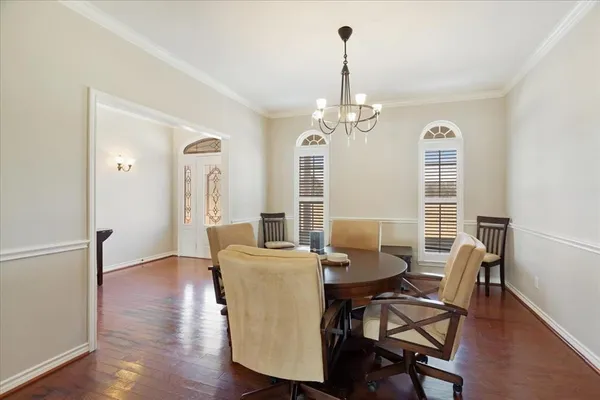 a view of a dining room with furniture wooden floor and chandelier