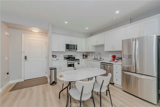 a kitchen with stainless steel appliances a refrigerator stove microwave and white cabinets