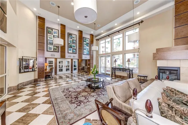 a living room with furniture large windows and wooden floor