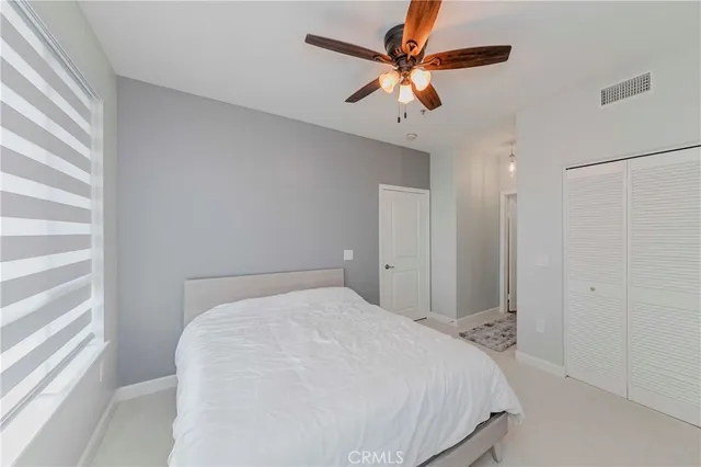 a bedroom with a large bed and a ceiling fan
