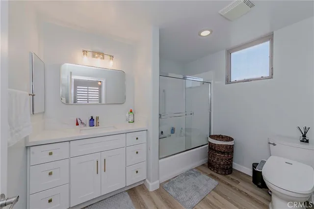 a bathroom with a toilet a sink and mirror