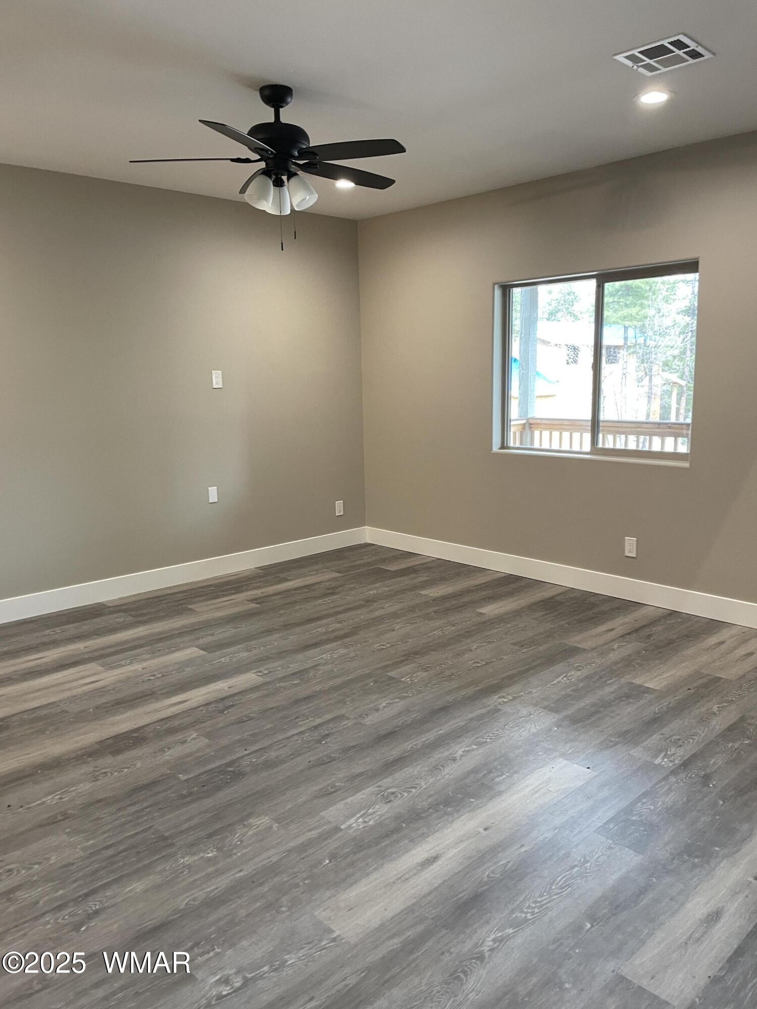 2426 Aspen Run Pinetop, AZ 85935 - Photo 12 of 44 an empty room with wooden floor fan and windows