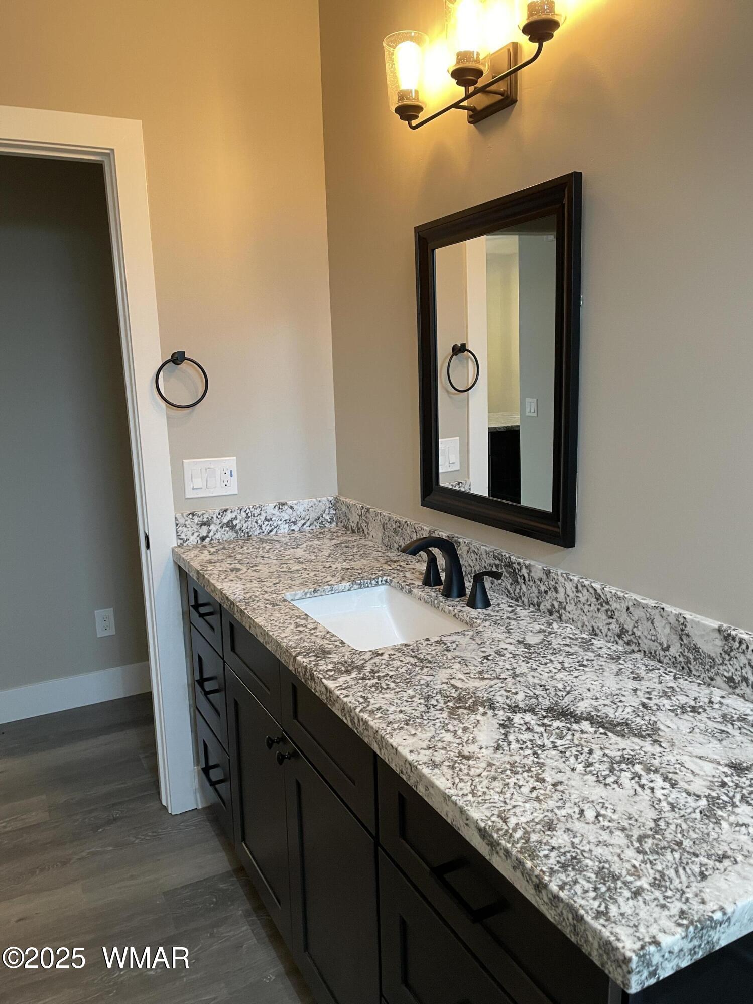 2426 Aspen Run Pinetop, AZ 85935 - Photo 19 of 44 a bathroom with a granite countertop sink and a mirror
