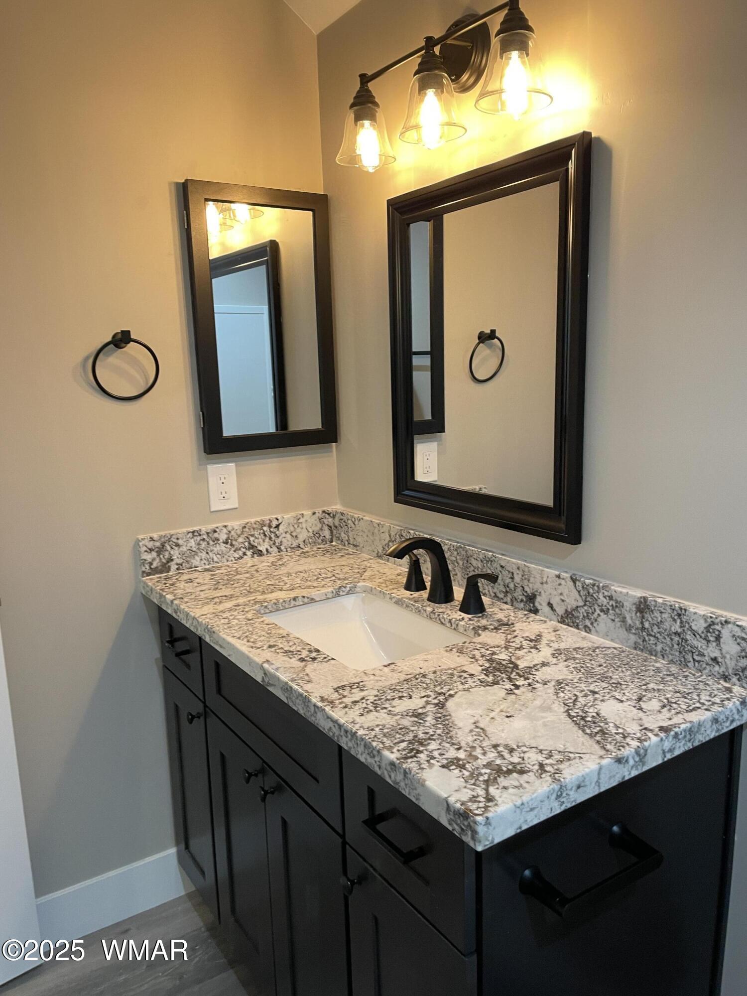 2426 Aspen Run Pinetop, AZ 85935 - Photo 32 of 44 a bathroom with a granite countertop sink and a mirror