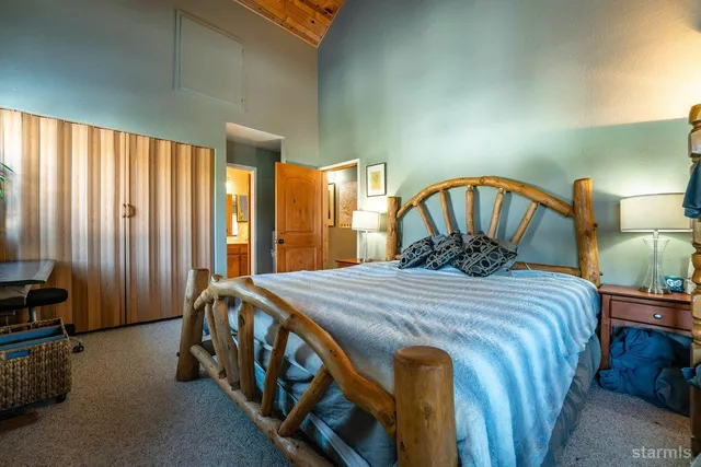 a bedroom with a bed a lamp and a large closet