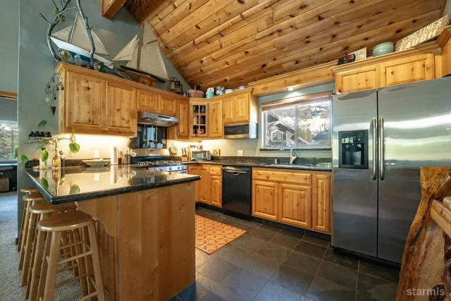 a kitchen with stainless steel appliances granite countertop a sink a counter space cabinets and stainless steel appliances