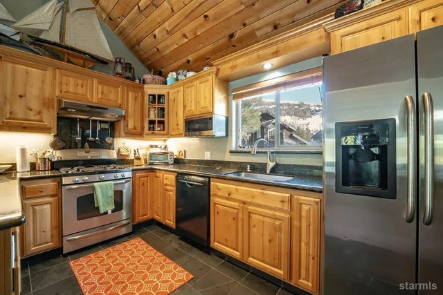 a kitchen with stainless steel appliances granite countertop a stove a sink and a microwave