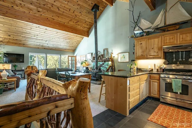 a kitchen with stainless steel appliances granite countertop a table chairs and a wooden floor
