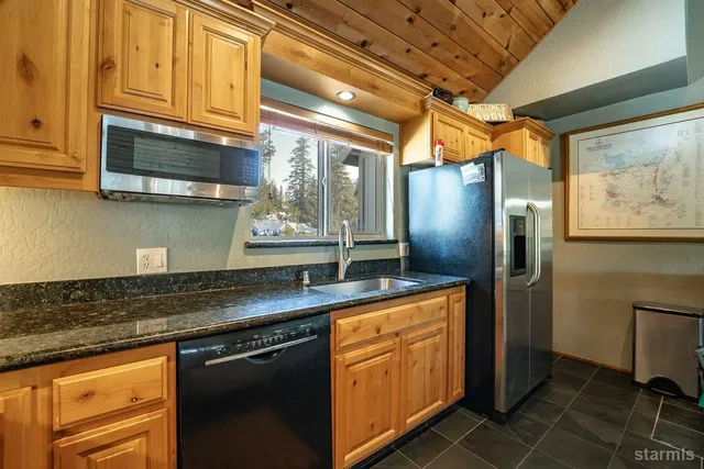 a kitchen with stainless steel appliances granite countertop a sink a stove and refrigerator