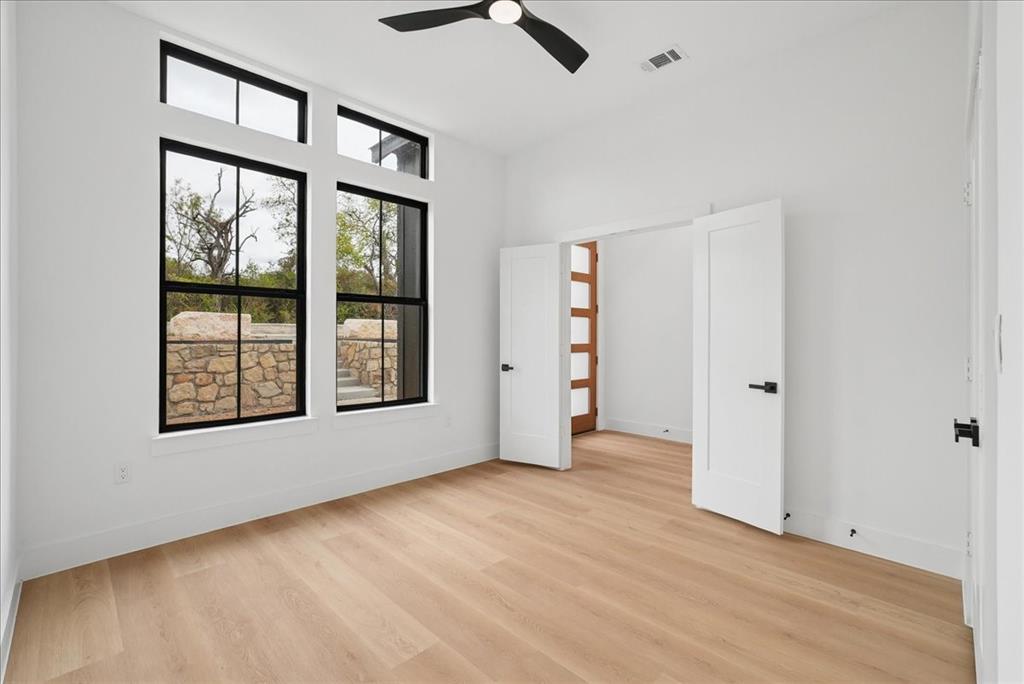 1648 West Wintergreen Road Lancaster, TX 75134 - Photo 19 of 23 Wood-finish flooring, white walls, and a black ceiling fan