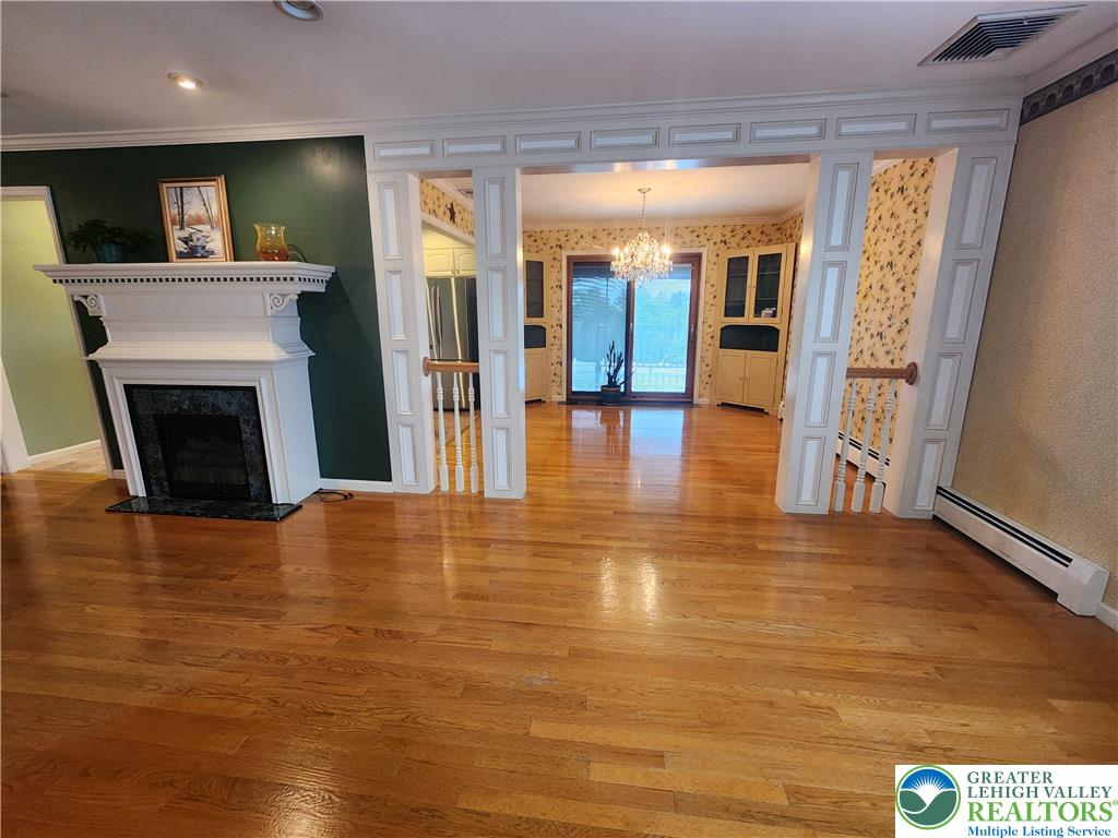 1480 Teels Road Pen Argyl, PA 18072 - Photo 7 of 18 Polished hardwood floors and a classic fireplace create a warm, inviting living space.