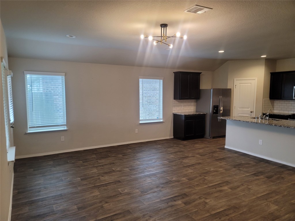 846 Autumn Flats Way Rosharon, TX 77583 - Photo 21 of 26 an empty room with wooden floor and a kitchen