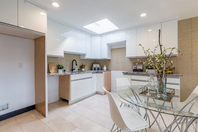a kitchen with granite countertop white cabinets and stainless steel appliances