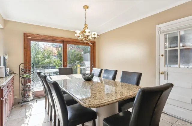 a dining room with wooden floor and a chandelier