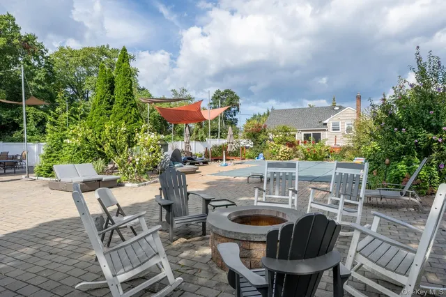 an outdoor sitting area with chairs and wooden fence