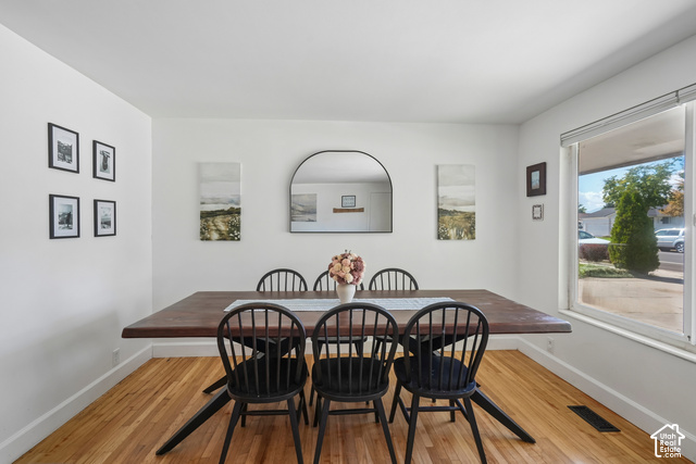 7391 Ramanee Drive Midvale, UT 84047 - Photo 8 of 45 Hardwood flooring, arched wall mirror, and a large window with a white frame