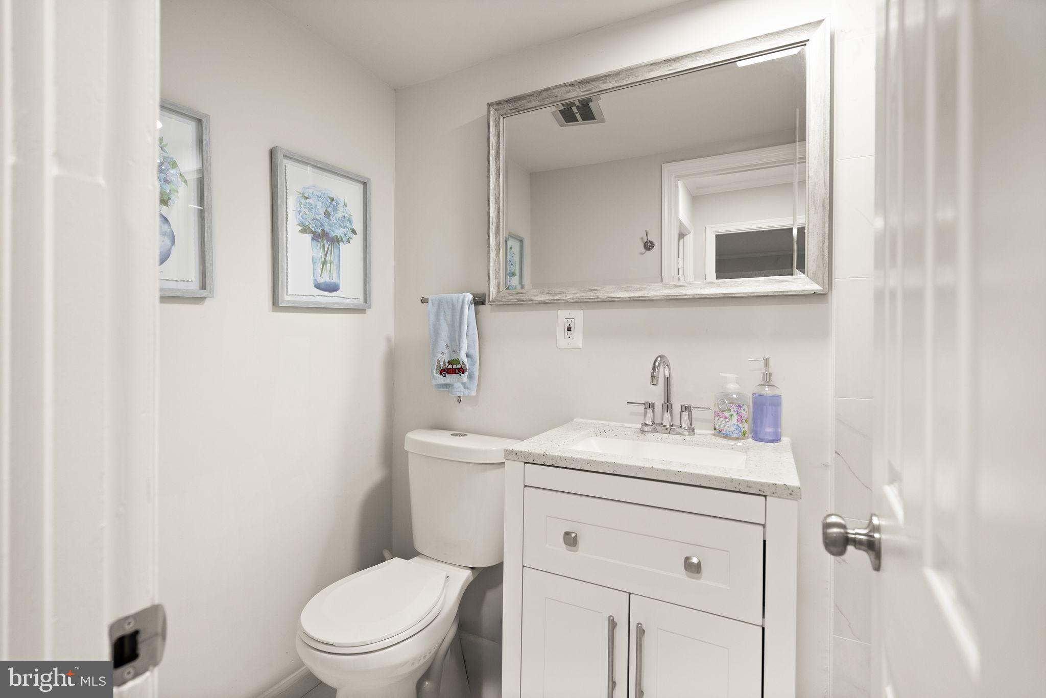 10808 Hunt Club Road Reston, VA 20190 - Photo 21 of 49 a bathroom with a toilet sink vanity and mirror