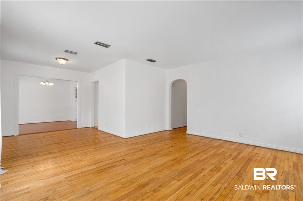 218 Grand Boulevard Mobile, AL 36607 - Photo 22 of 22 Empty room featuring light hardwood / wood-style flooring and an inviting chandelier