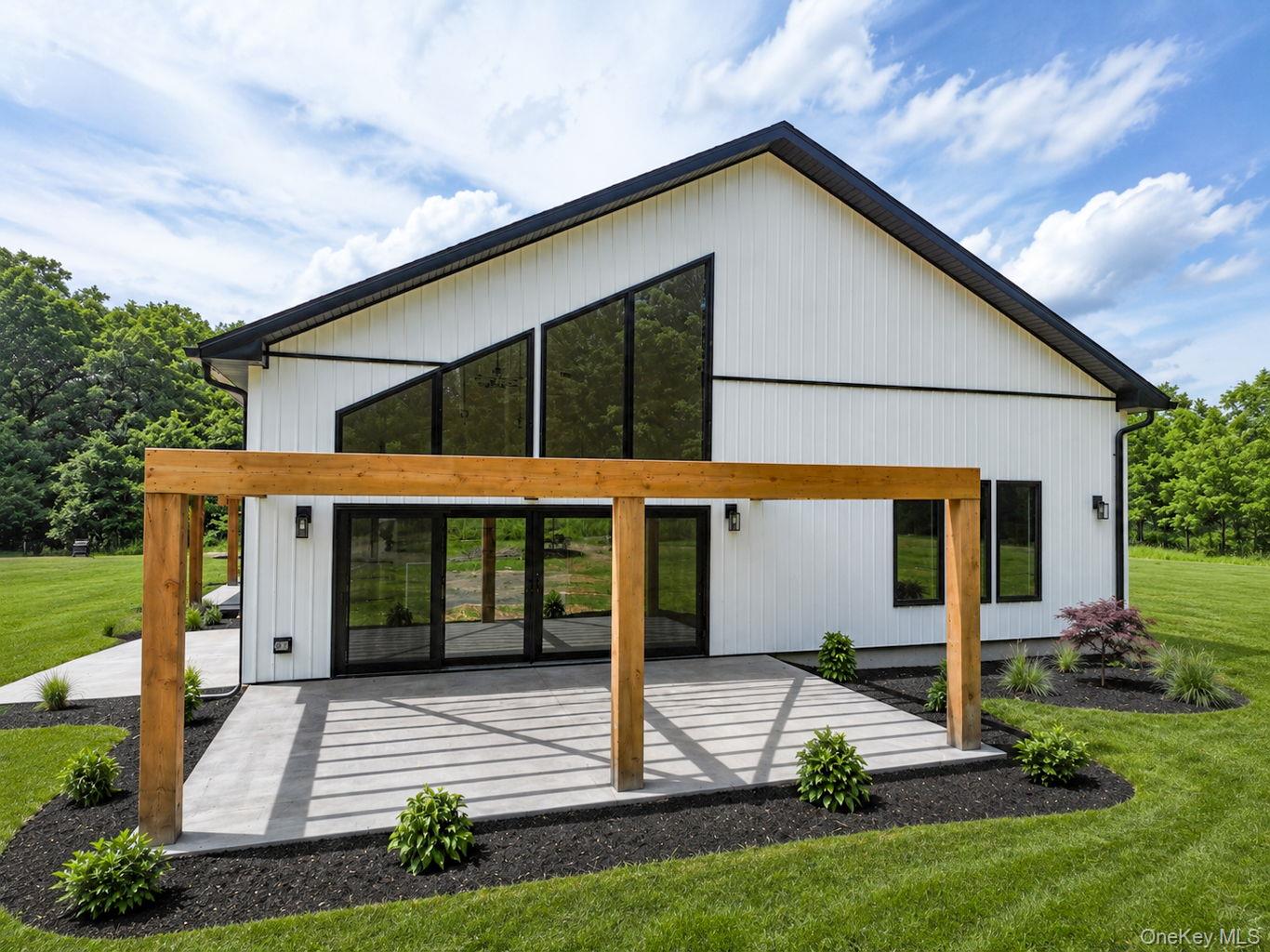 128 St Elmo Road Wallkill, NY 12589 - Photo 4 of 45 Stamped concrete patio with pergola and extra large sliding door to indoor dining area. Digitally enhanced for lighting and cosmetic grass colorization