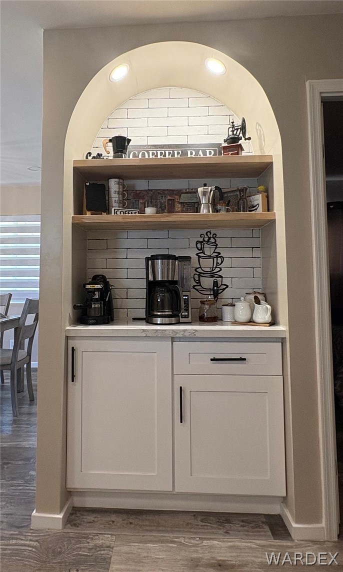 1395 Lause Road Bullhead City, AZ 86442 - Photo 12 of 34 Built-in arched coffee bar featuring recessed lighting, open wood-finish shelving, subway tile backsplash, and lower cabinetry with a solid surface countertop
