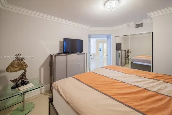 a bedroom with a bed and a flat screen tv