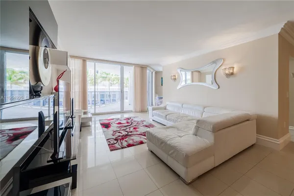 a bedroom with a bed couch and a flat tv screen next to a window