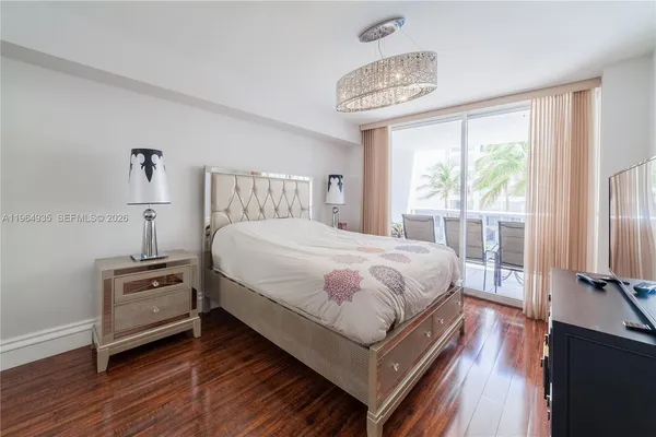 a bedroom with a bed a large window with wooden floor
