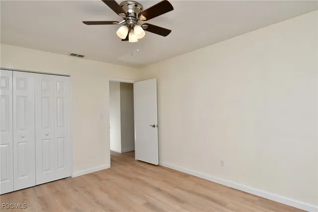 an empty room with a ceiling fan and a window