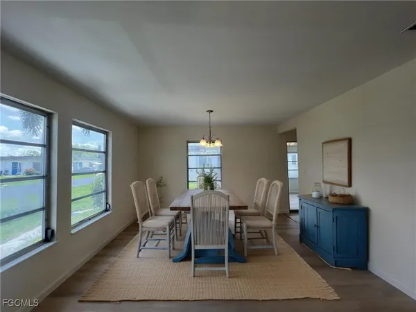 a dining room with furniture a chandelier and window