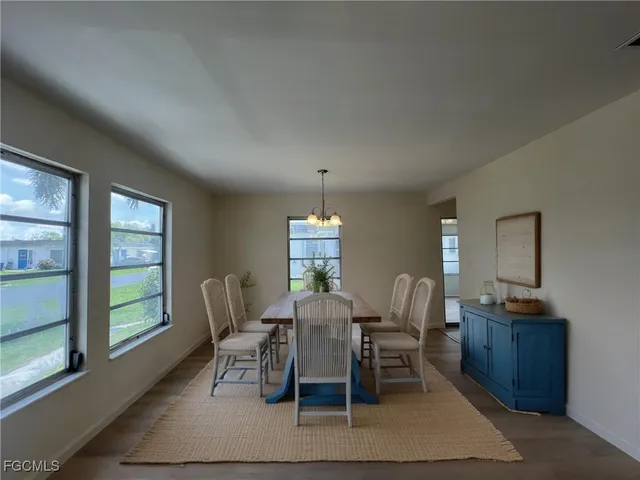 a dining room with furniture a chandelier and window
