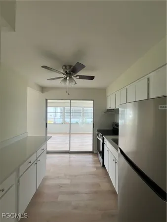 a view of a kitchen with a sink and dishwasher with wooden floor