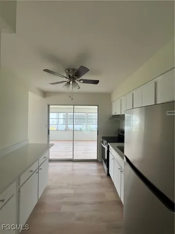 a view of a kitchen with a sink and dishwasher with wooden floor