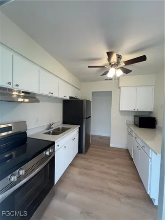 a kitchen with stainless steel appliances a sink dishwasher a stove and a refrigerator