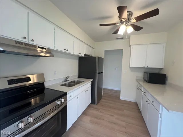 a kitchen with stainless steel appliances a stove a sink and a refrigerator