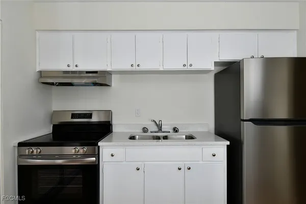 a kitchen with a refrigerator and a stove