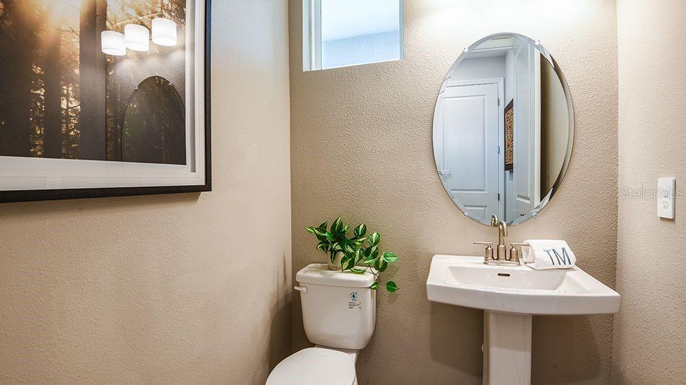 32488 Sea Loch Loop Mount Dora, FL 32757 - Photo 21 of 31 a bathroom with a toilet a sink and mirror