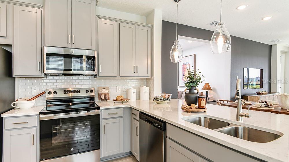 32488 Sea Loch Loop Mount Dora, FL 32757 - Photo 6 of 31 a kitchen with granite countertop white cabinets white stainless steel appliances and sink