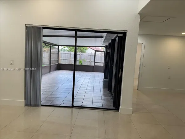 an empty room with sliding door and a floor to ceiling window