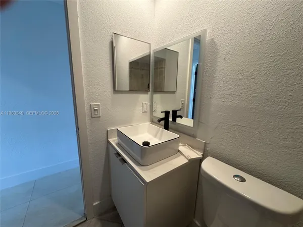 a bathroom with a sink toilet and mirror
