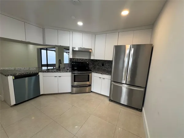 a kitchen with stainless steel appliances granite countertop a refrigerator sink stove microwave and cabinets
