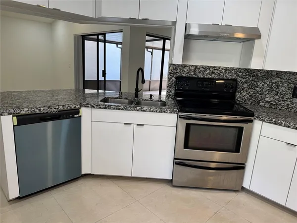 a kitchen with granite countertop a stove and a sink