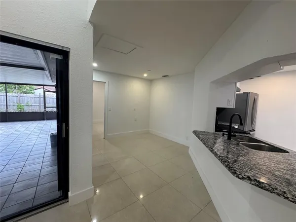 a bathroom with a granite countertop sink a mirror and shower