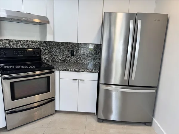 a kitchen with metallic refrigerator and stove