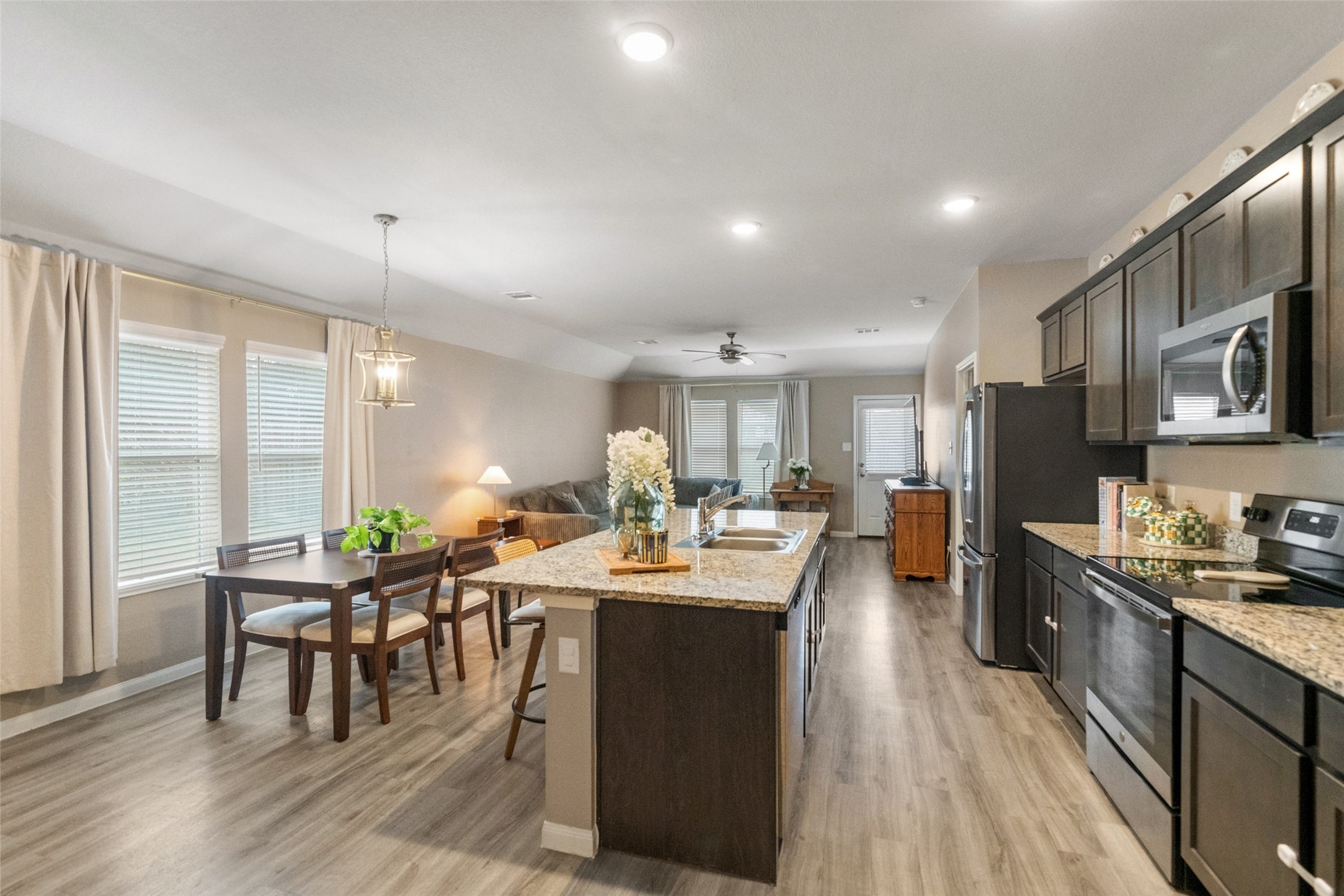 26431 Pin Oak Drive Hempstead, TX 77445 - Photo 9 of 32 Open-concept kitchen and dining area featuring a large island with seating and plenty of prep space. The layout flows easily into the living room—ideal for everyday living and entertaining.