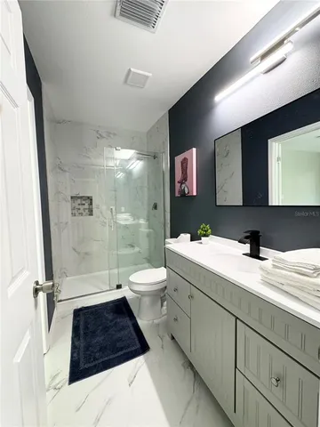 a bathroom with a double vanity sink toilet and shower