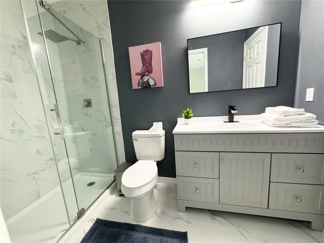 a bathroom with a sink toilet and shower