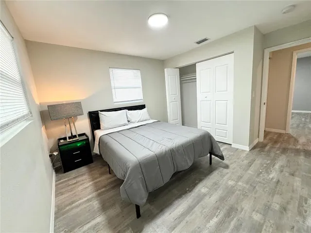 a bedroom with a bed and wooden floor